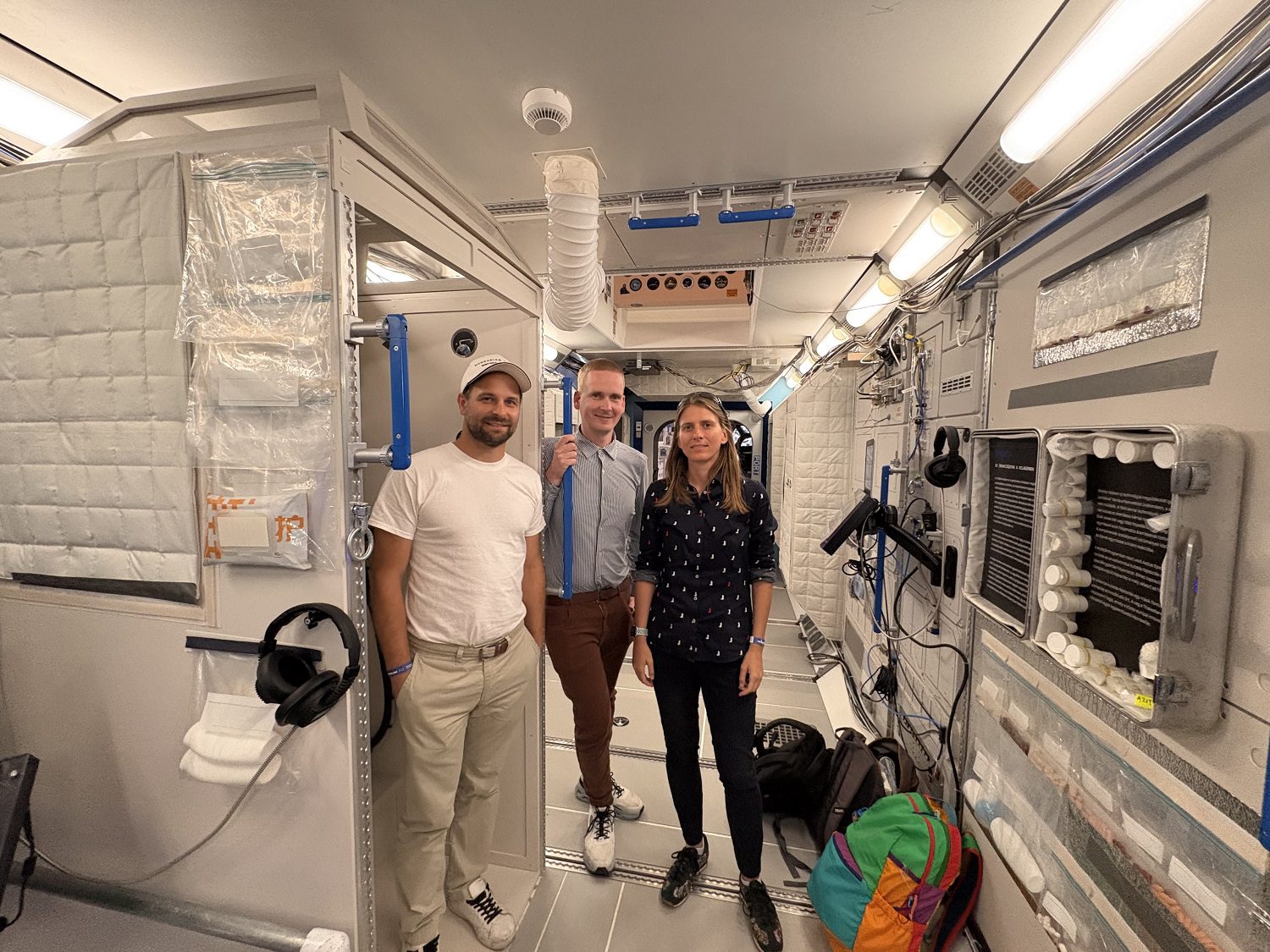 Balról jobbra: Prazsák István, Gulyás Gábor és Tombácz Dóra a Huniverzum kiállításon, az ISS azon területének másolata előtt, ahol a kísérletek részben zajlottak